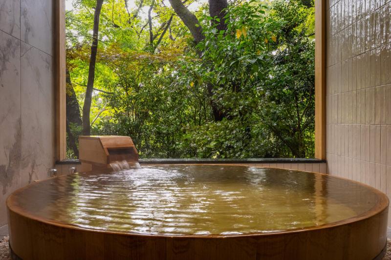 緑を望む木の湯船の客室露天風呂の写真