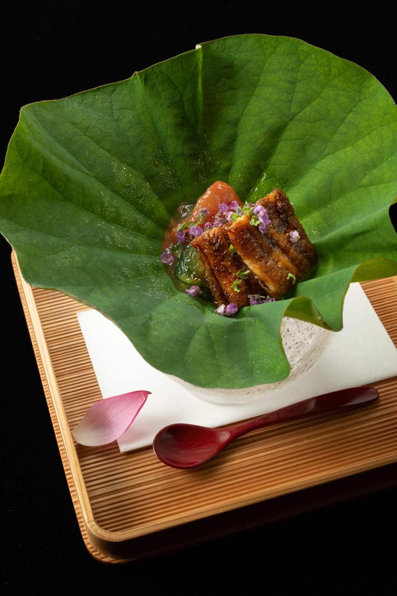蓮の葉に盛り付けた焼き物の料理写真